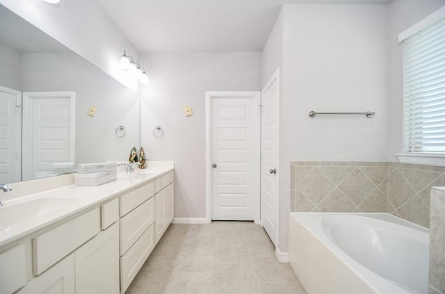 bathroom featuring tile patterned flooring, vanity, and a bath