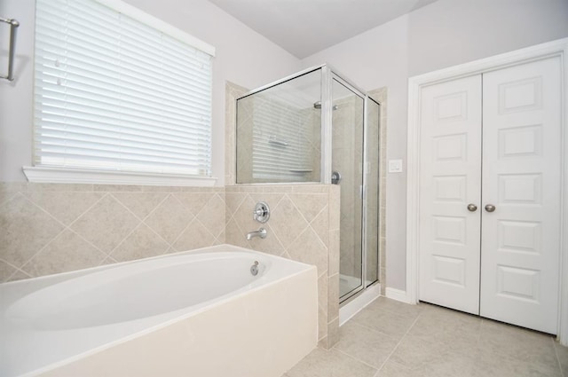 bathroom featuring tile patterned flooring and separate shower and tub