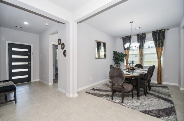 tiled dining area featuring an inviting chandelier