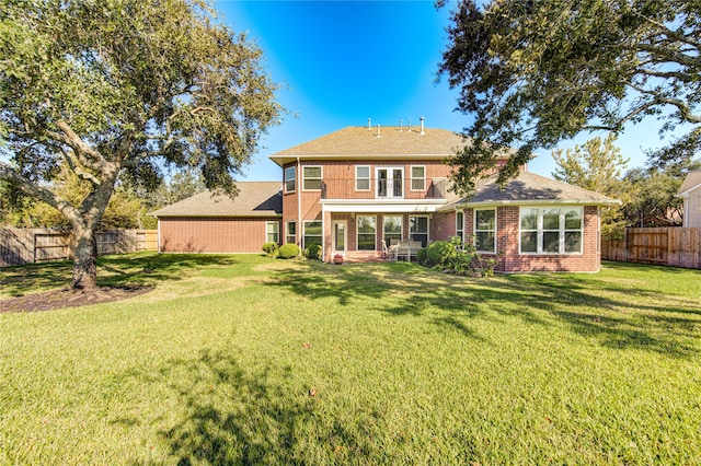 back of house featuring a sunroom and a lawn