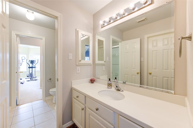 bathroom with tile patterned flooring, vanity, and toilet