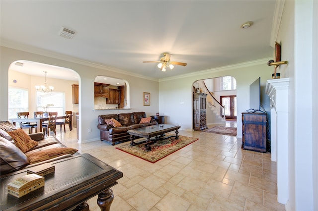 living room with ceiling fan with notable chandelier and ornamental molding