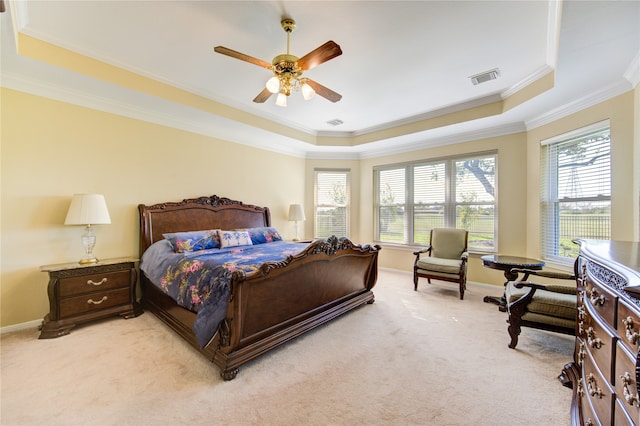 carpeted bedroom featuring ceiling fan, crown molding, and a tray ceiling