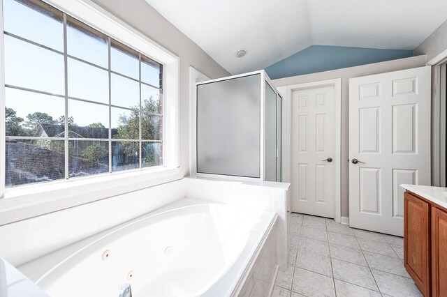 bathroom with tile patterned floors, vanity, shower with separate bathtub, and vaulted ceiling