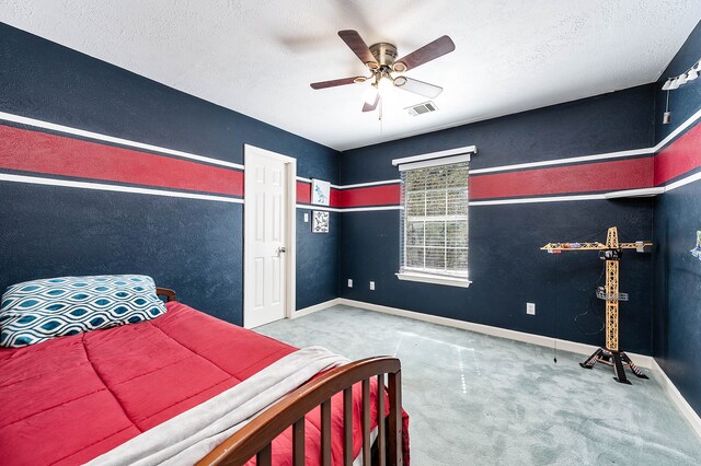 bedroom featuring ceiling fan, carpet floors, and a textured ceiling