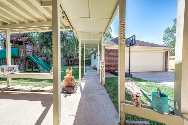 view of patio / terrace with a playground and a garage