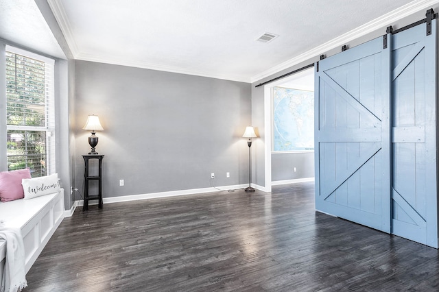 interior space with a barn door, dark hardwood / wood-style flooring, and ornamental molding