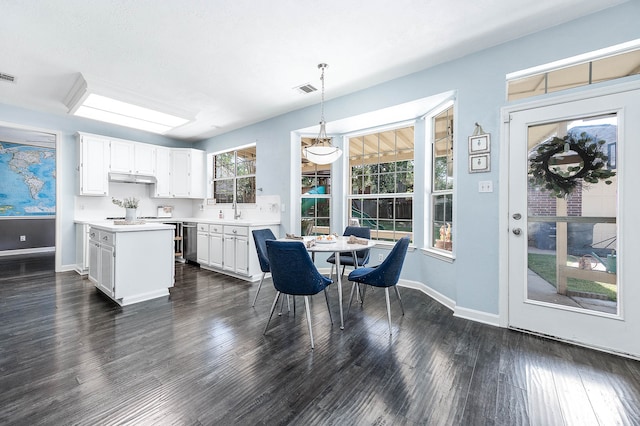 kitchen with a center island, dark hardwood / wood-style flooring, white cabinetry, and hanging light fixtures