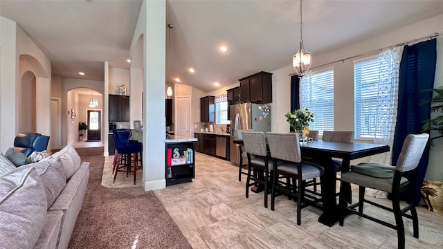 dining space with an inviting chandelier and vaulted ceiling