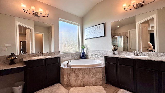 bathroom featuring vanity, lofted ceiling, and independent shower and bath