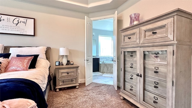 bedroom featuring ensuite bath and carpet