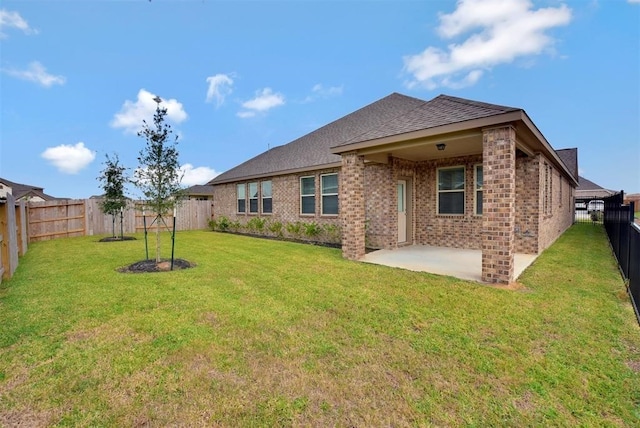 back of house with a patio area and a lawn