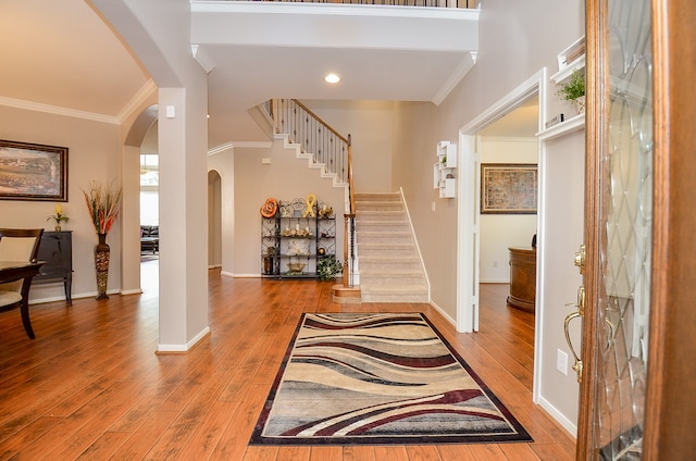 foyer entrance with hardwood / wood-style floors and crown molding