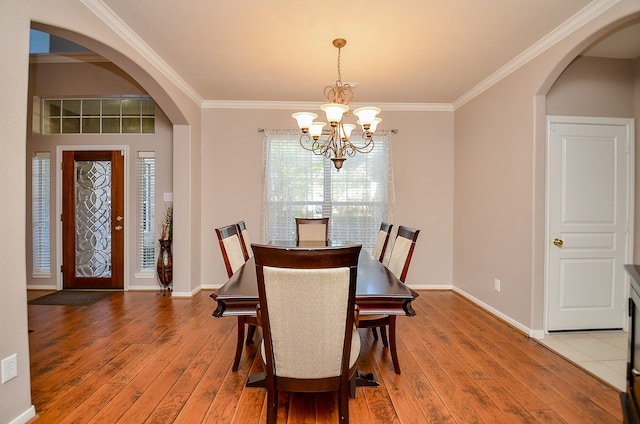 dining room featuring hardwood / wood-style floors, an inviting chandelier, and ornamental molding