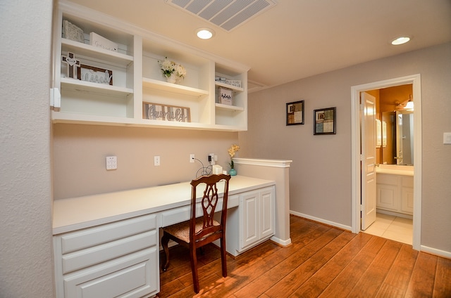 office area with built in desk and light hardwood / wood-style floors