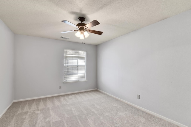 carpeted spare room featuring a textured ceiling and ceiling fan