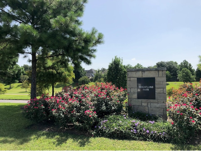 community / neighborhood sign featuring a yard