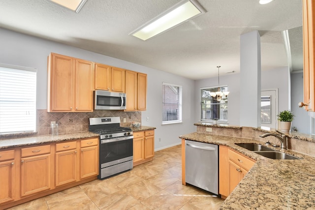 kitchen with sink, plenty of natural light, pendant lighting, and appliances with stainless steel finishes