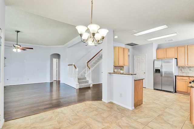 kitchen with stainless steel fridge, light wood-type flooring, tasteful backsplash, ceiling fan with notable chandelier, and light brown cabinets