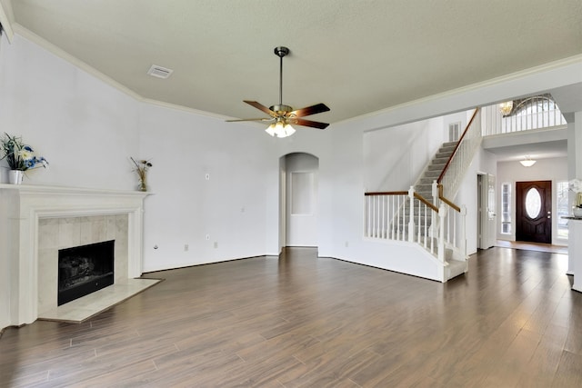 unfurnished living room with dark wood-type flooring, a healthy amount of sunlight, and ornamental molding