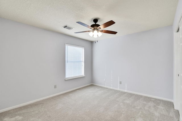 carpeted empty room featuring ceiling fan and a textured ceiling