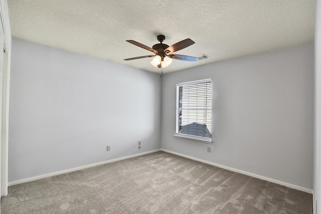 carpeted spare room featuring ceiling fan and a textured ceiling