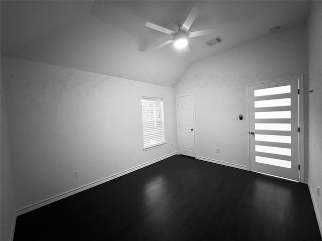 empty room with ceiling fan, dark hardwood / wood-style flooring, and lofted ceiling