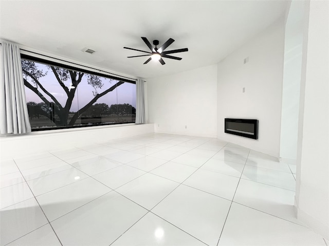 unfurnished living room featuring ceiling fan and light tile patterned floors