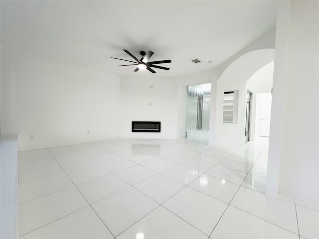 unfurnished living room featuring ceiling fan and light tile patterned flooring