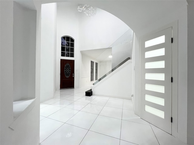 tiled entryway featuring a towering ceiling