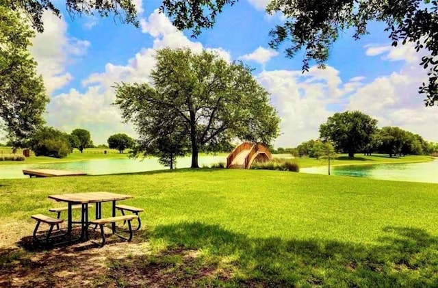 view of community with a lawn and a water view