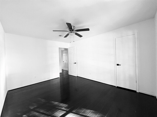 unfurnished room featuring dark hardwood / wood-style floors and ceiling fan