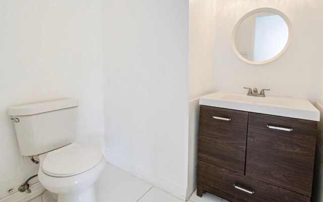 bathroom with toilet, vanity, and tile patterned floors