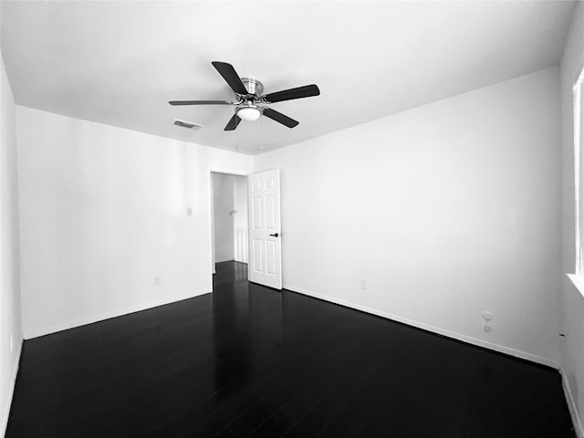 empty room with ceiling fan and dark hardwood / wood-style flooring