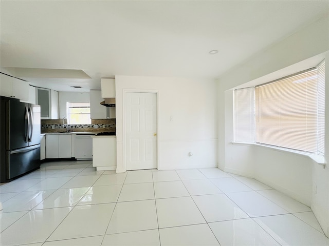 kitchen featuring white cabinetry, dishwasher, sink, stainless steel fridge, and decorative backsplash