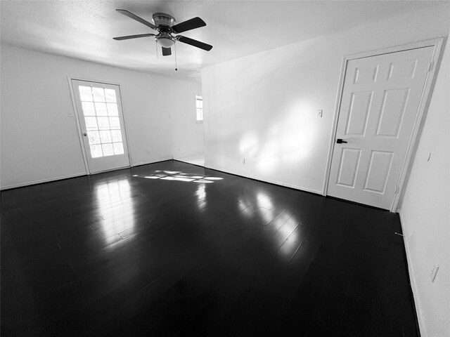 spare room featuring ceiling fan and dark wood-type flooring