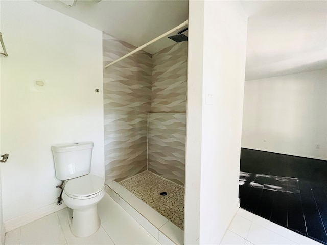 bathroom featuring tile patterned floors, a shower, tile walls, and toilet