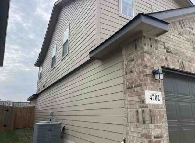 view of property exterior with a garage and central air condition unit