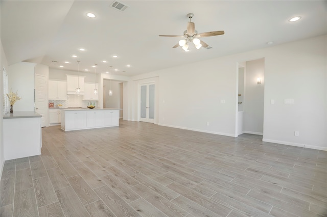 unfurnished living room with ceiling fan and light hardwood / wood-style flooring