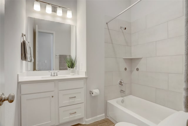 bathroom featuring hardwood / wood-style floors, tiled shower / bath combo, and vanity