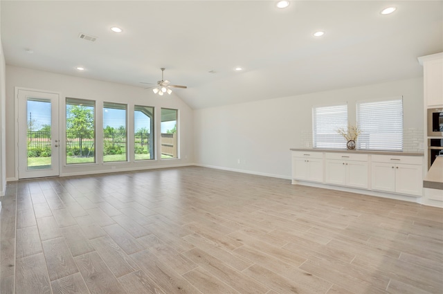 unfurnished living room with light wood-type flooring, vaulted ceiling, and ceiling fan