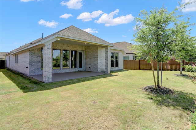 back of property featuring a lawn and a patio area