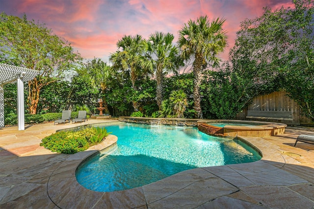 pool at dusk featuring a pergola, a patio area, and an in ground hot tub