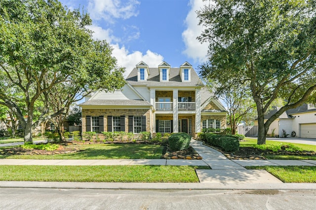 view of front facade featuring a front yard and a balcony