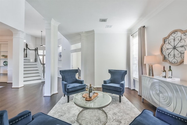 living area featuring ornamental molding, dark hardwood / wood-style floors, and ornate columns