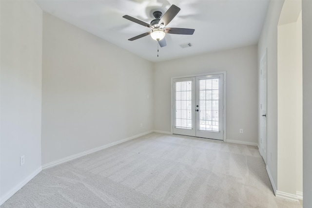 empty room with light carpet, ceiling fan, and french doors