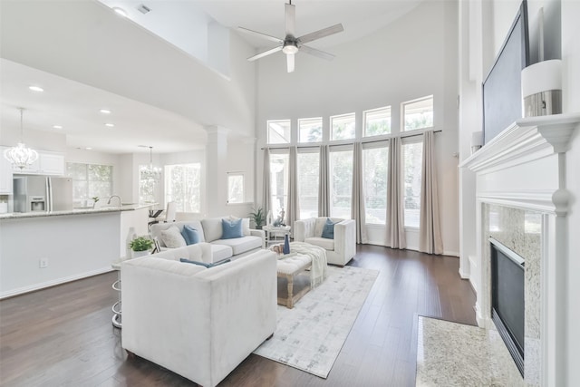 living room featuring dark wood-type flooring, a wealth of natural light, and a fireplace