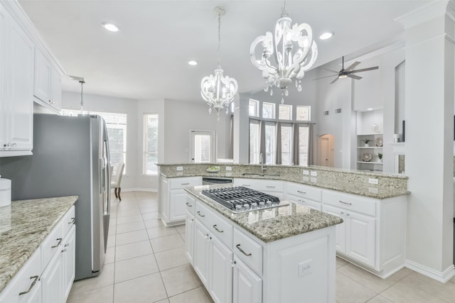 kitchen featuring pendant lighting, sink, stainless steel appliances, a center island, and white cabinets