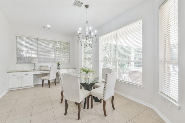 dining room with an inviting chandelier, built in desk, and light tile patterned floors