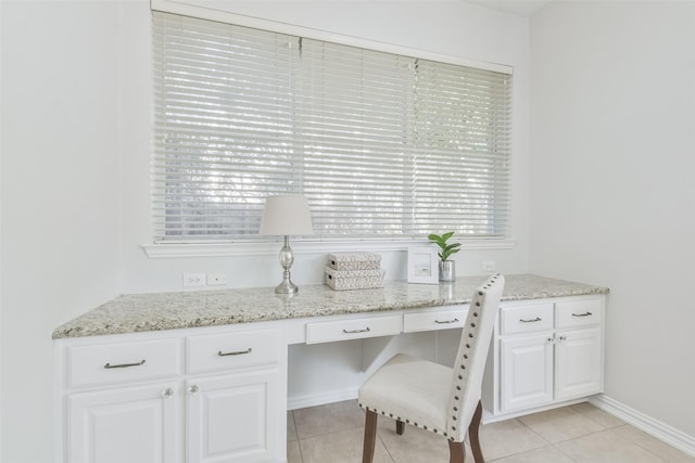 home office with built in desk and light tile patterned floors